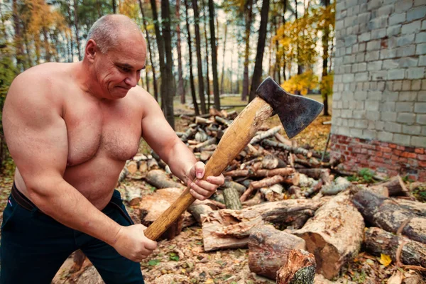 Ένας δυνατός άντρας κόβει ξύλα.. — Φωτογραφία Αρχείου