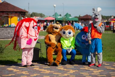 08 29 2020 Belarus, Lyaskovichi. Şehirde bir kutlama var. Kürk kostümlü sanatçılar bankta yorgun otururlar..