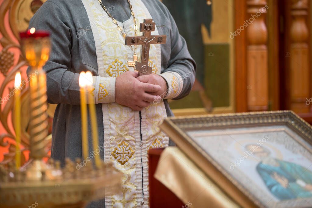 Sacerdotes mano con una cruz en el fondo de las velas de la iglesia. 2023