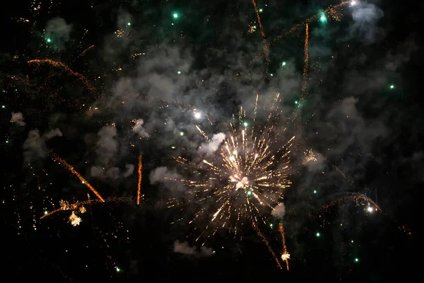 Macchie colorate di fuochi d'artificio in fumo verde su sfondo nero. Sfondo festivo. — Foto Stock