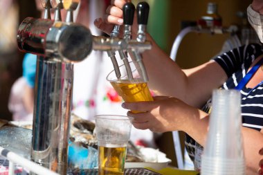 Satıcıların elleri birayı doldurur. Bira fıçısı..