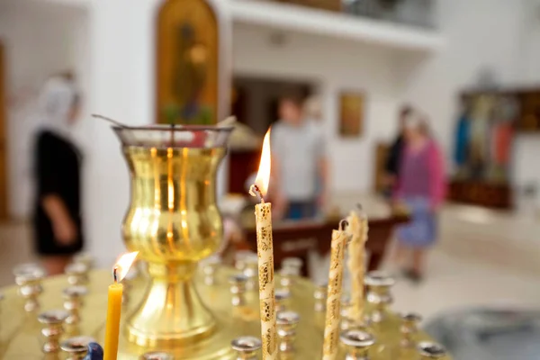 Kerkkaarsen op de achtergrond van wazige mensen. — Stockfoto