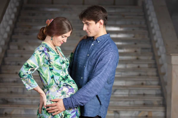 Kocası gri arka planda hamile bir kadın.. — Stok fotoğraf