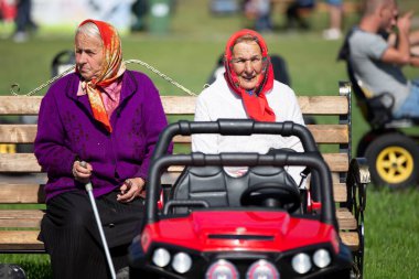 29 Ağustos 2020 Belarus, Gomil. Şehir tatili. Arabanın arka planında yaşlı Rus büyükanneler var..