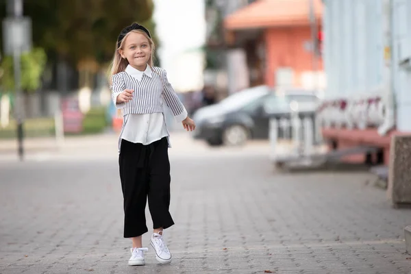 Радостная маленькая девочка на улице города. Ребенок в городской обстановке. — стоковое фото