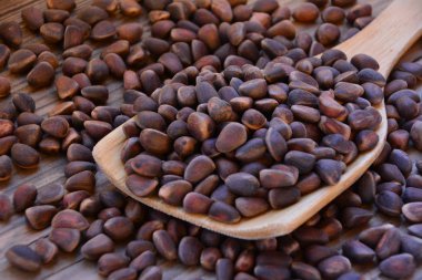 Çam fıstığı ahşap tahta arka plan üzerinde tahta kaşık içinde. Çam fıstığı.