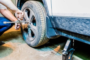 Mechanician değişen araba tekerleği garajda. Adam değiş tokuşu lastik. Lastik servisi. Lastik montaj.