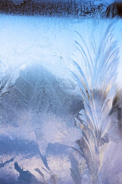 Beautiful ice pattern on winter glass, natural texture. Winter patterns on windows glass.