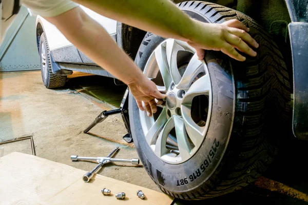 Mechanician değişen araba tekerleği garajda. Adam değiş tokuşu lastik. Lastik servisi. Lastik montaj.