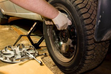 Mechanician değişen araba tekerleği garajda. Adam değiş tokuşu lastik. Lastik servisi. Lastik montaj.