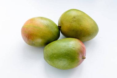 Beyaz zemin üzerinde üç olgun mango. Mango tropik ağaçların çiçekli bitki cins Mangifera ait çok sayıda türlerden sulu taş meyve (drupe) vardır. Tropikal meyve.