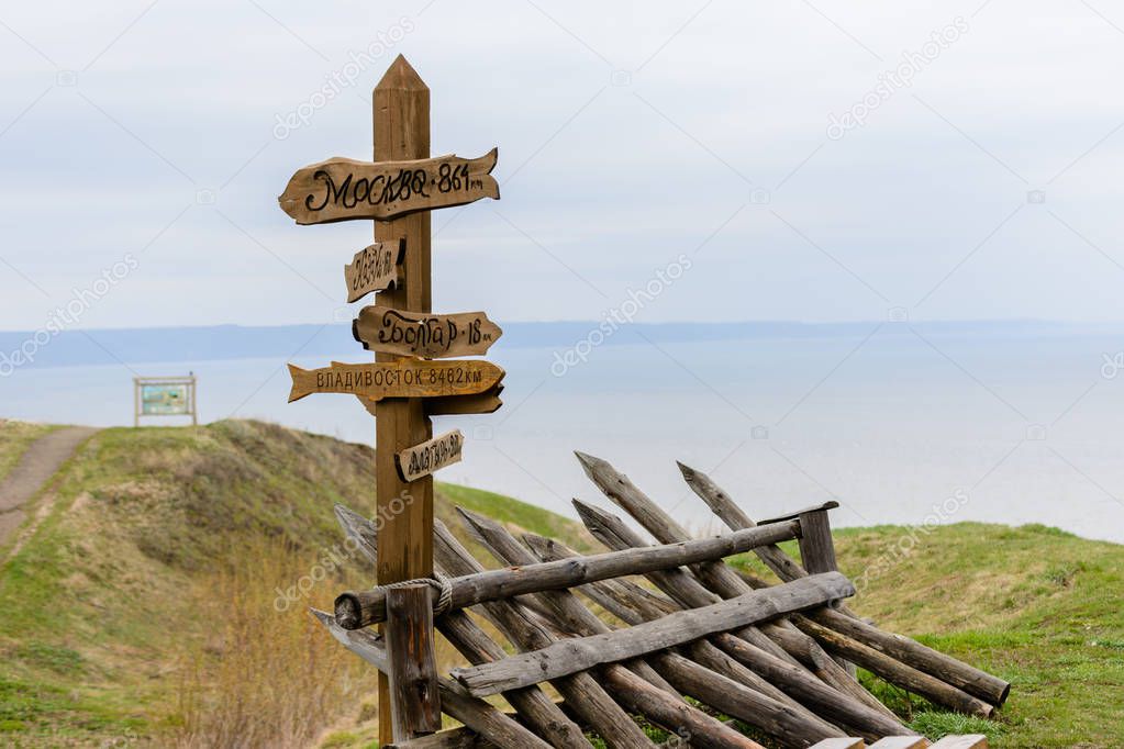 Direction arrows to the different popular towns with the distance to each city given in kilometers. Wooden signpost to Moscow, Kazan, Vladivostok, Bolgar, Alatyr. Tetyushi, Russia. 
