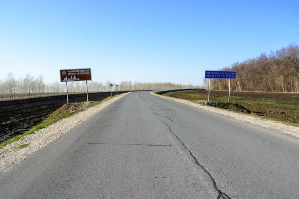 Tataristan'a hoş geldin diyelim. Kırsal bir yolda Tataristan tabelası. Açık mavi gökyüzüne karşı Tataristan yol işareti. Asfalt yol yakın çekim.