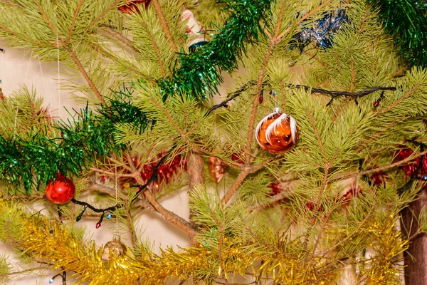輝く花輪を背景にクリスマスツリーにカラフルなクリスマス風船 クリスマスツリーの枝に囲まれたカラフルなボール クリスマスコンセプト — ストック写真