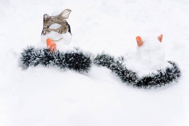Kış manzarasında beyaz kar yığınlarının arka planında duran kedi şeklinde kardan adamlar. Çok fazla kar var..
