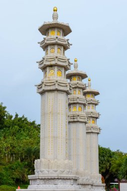 Sanya, Hainan, Çin - 20 Şubat 2020: Bulutlu bir günde Budist merkez Nanshan 'ın topraklarında Budist taş sütunlar (dua sütunları).