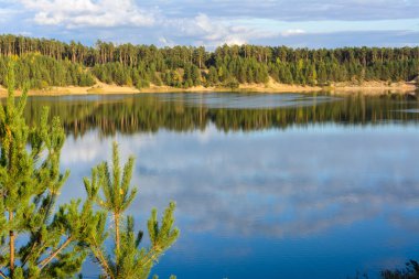 Yapısal bulutları, kumlu dağları ve ormanı olan Emerald Gölü. Yüksek bir dağın manzarası. Kazan, Rusya.