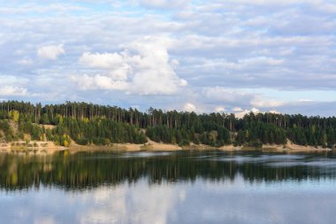 Yapısal bulutları, kumlu dağları ve ormanı olan Emerald Gölü. Yüksek bir dağın manzarası. Kazan, Rusya.