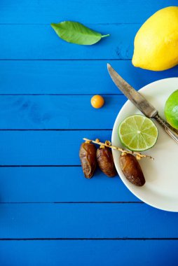 Limes limon ve mavi ahşap arka plan, limonata malzemeleri kavramı tarihleri