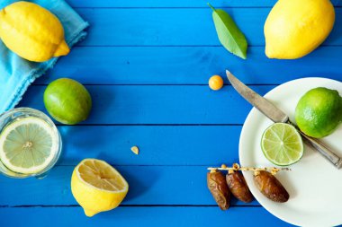 Limes Tarih ve limon ile yaz içki cam mavi ahşap arka plan, limonata malzemeleri kavramı üzerinde