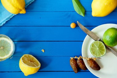 Limes Tarih ve limon ile yaz içki cam mavi ahşap arka plan, limonata malzemeleri kavramı üzerinde