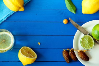 Limes Tarih ve limon ile yaz içki cam mavi ahşap arka plan, limonata malzemeleri kavramı üzerinde