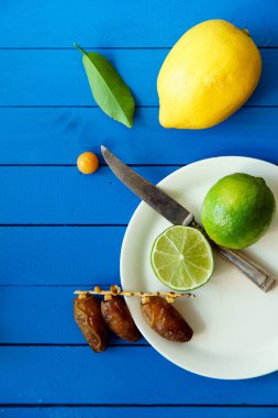 Limes limon ve mavi ahşap arka plan, limonata malzemeleri kavramı tarihleri