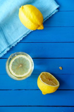 cam ve masa örtüsü mavi ahşap zemin, limonata malzemeleri kavramı üzerine yaz ile limon içecek 