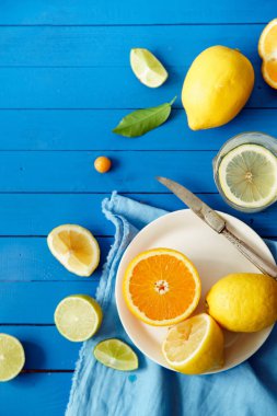 Turuncu mavi ahşap arka plan, limonata malzemeleri kavramı kireç ve limon dilimleri ile