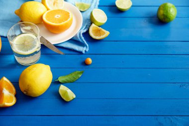 Turuncu mavi ahşap arka plan, limonata malzemeleri kavramı kireç ve limon dilimleri ile