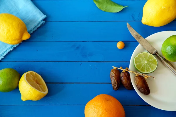 Narenciye limonata malzemeleri kavramı mavi ahşap arka plan üzerinde tarihleri ile