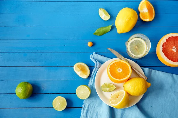 Citrus fruit slices on blue wooden background, Lemonade ingredients concept