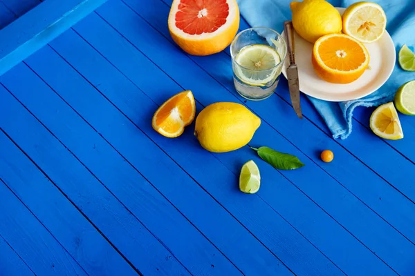Mavi ahşap arka plan, limonata malzemeleri kavramı narenciye meyve dilimleri