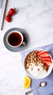 Yoğurt ve çilek kase ve mermer masa üzerinde siyah kahve ile gevrek gevrek mükemmel kahvaltı