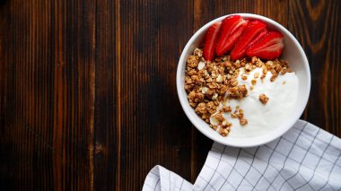 yoğurt ve tahta masada damalı masa örtüsü kase çilek ile lezzetli gevrek gevrek yakın çekim 