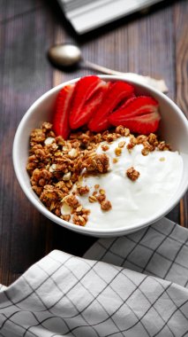 yoğurt ve tahta masada damalı masa örtüsü kase çilek ile lezzetli gevrek gevrek yakın çekim 