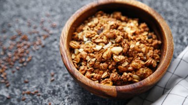 Granola ahşap kase ve gri arka plan üzerinde masa örtüsü