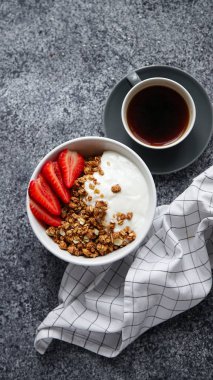 gevrek gevrek yoğurt ve çilek kase ve beyaz gri arka plan üzerinde siyah sıcak kahve fincan ile kahvaltı mükemmel 