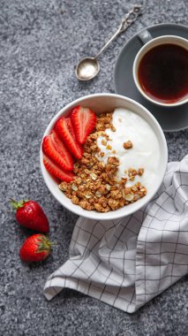 gevrek gevrek yoğurt ve çilek kase ve beyaz gri arka plan üzerinde siyah sıcak kahve fincan ile kahvaltı mükemmel 