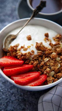 gevrek gevrek yoğurt ve çilek kase ve beyaz gri arka plan üzerinde siyah sıcak kahve fincan ile kahvaltı mükemmel 