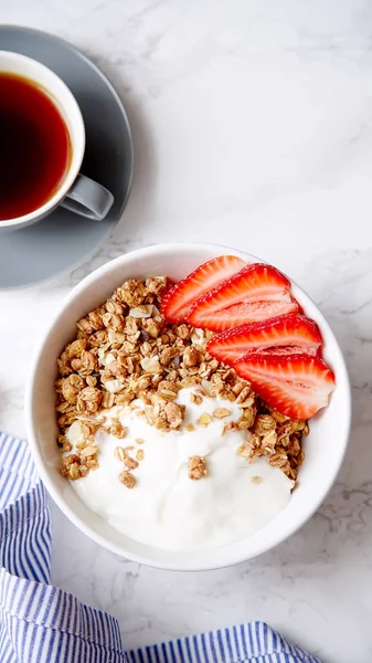 Yoğurt ve çilek kase ve mermer masa üzerinde siyah kahve ile gevrek gevrek mükemmel kahvaltı 