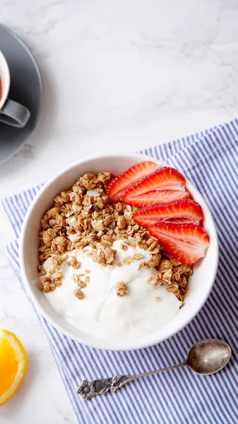 Yoğurt ve çilek kase ve mermer masa üzerinde siyah kahve ile gevrek gevrek mükemmel kahvaltı 