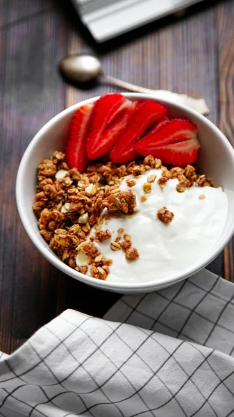 yoğurt ve tahta masada damalı masa örtüsü kase çilek ile lezzetli gevrek gevrek yakın çekim 