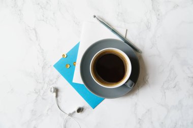 Çalışma alanı ile defter ve laptop ile kahve fincanı ve mermer masa üzerinde kulaklık