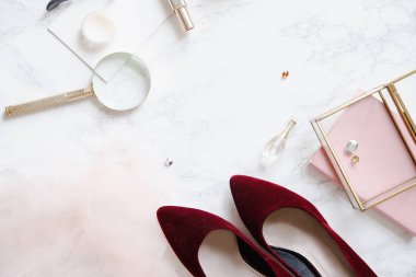 kadınsı aksesuarları ve mermer zemin üzerine kırmızı yüksek topuklu ayakkabılar