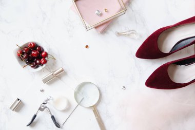 kadınsı aksesuarları ve mermer zemin üzerine kase kiraz kırmızı yüksek topuklu ayakkabılarla