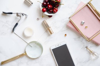 mock-up smartphone ve kase mermer zemin üzerine kırmızı kiraz ile kadınsı aksesuarları