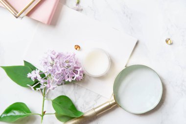 kadınsı çalışma alanı mock-up kartı ve defter ile Lila çiçek ve mermer zemin üzerine büyüteç ile