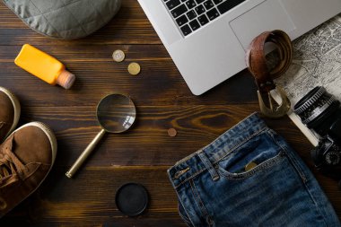 Laptop ile kamera ve büyüteç ile eski vintage ahşap masa, blogger çalışma alanı kavramı üzerinde erkek giyimi