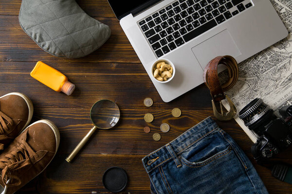 laptop with camera and magnifier with male clothes on old vintage wooden table, concept of blogger workspace